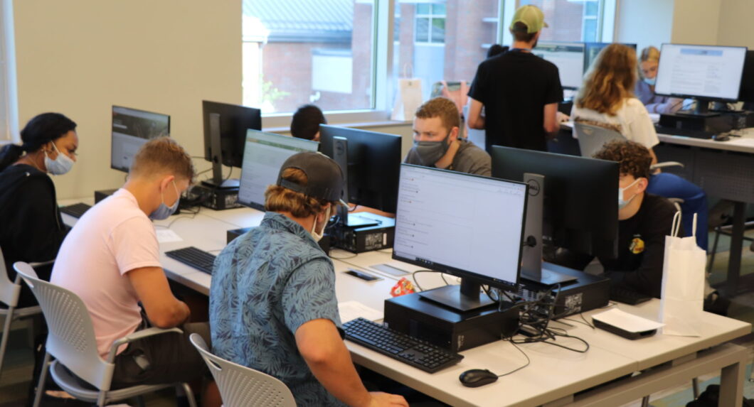 Students seated at tables with computers on them