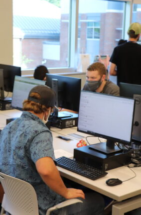 Students seated at tables with computers on them