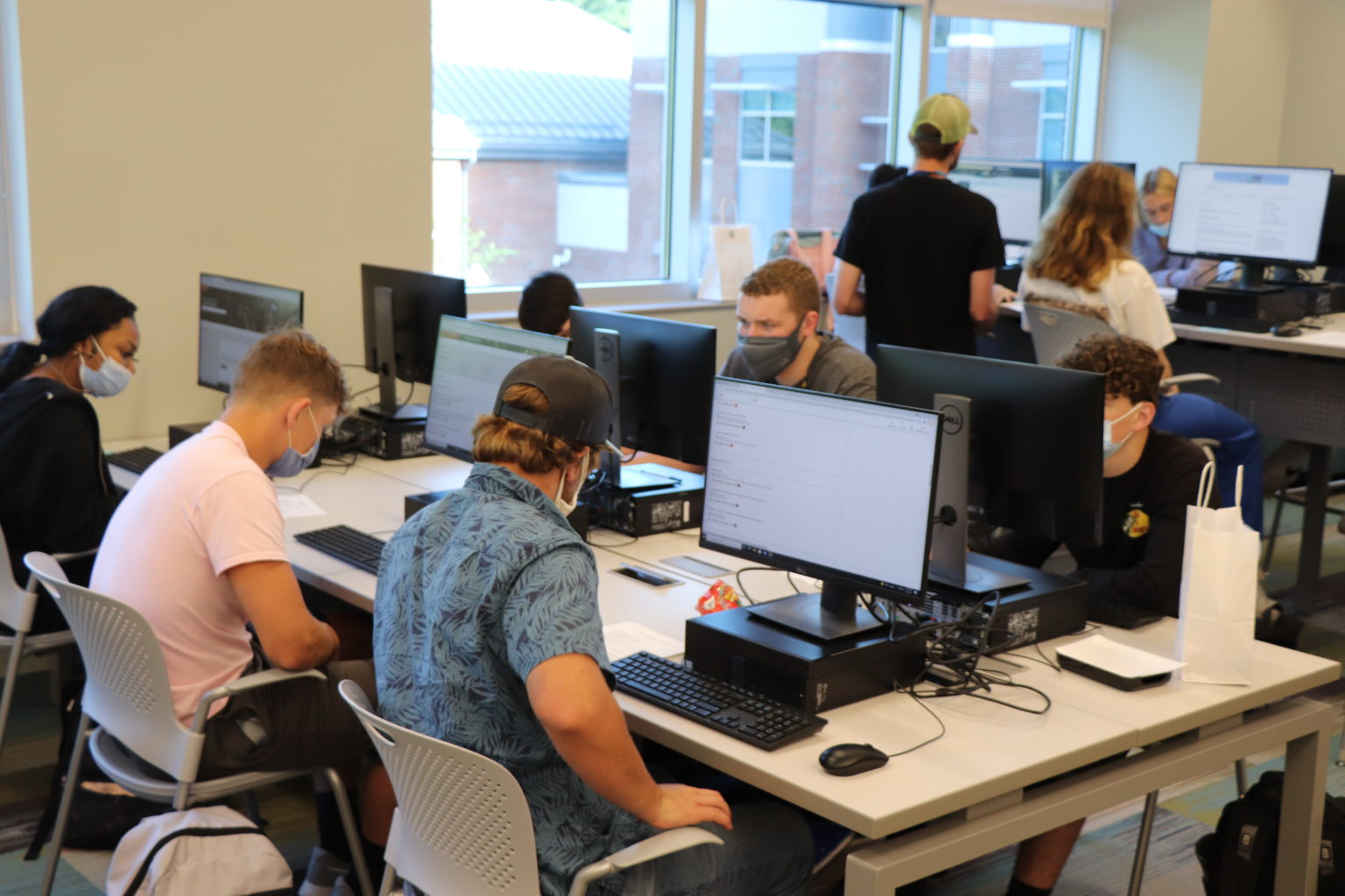 Students seated at tables with computers on them