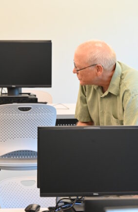 Two people standing among rows of computer workstations