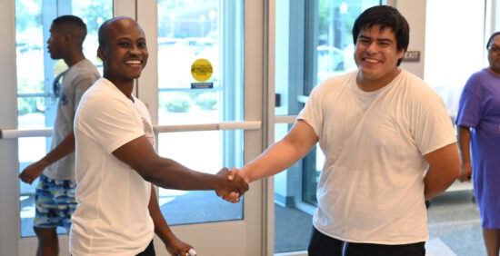 Two men standing in a foyer shaking hands
