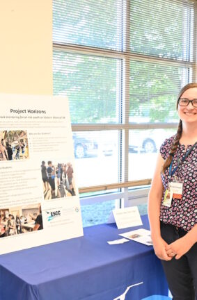 Two people standing in front of a table featuring Project Horizons