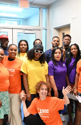 A group of people standing in a hallway in front of doors leading outside the building