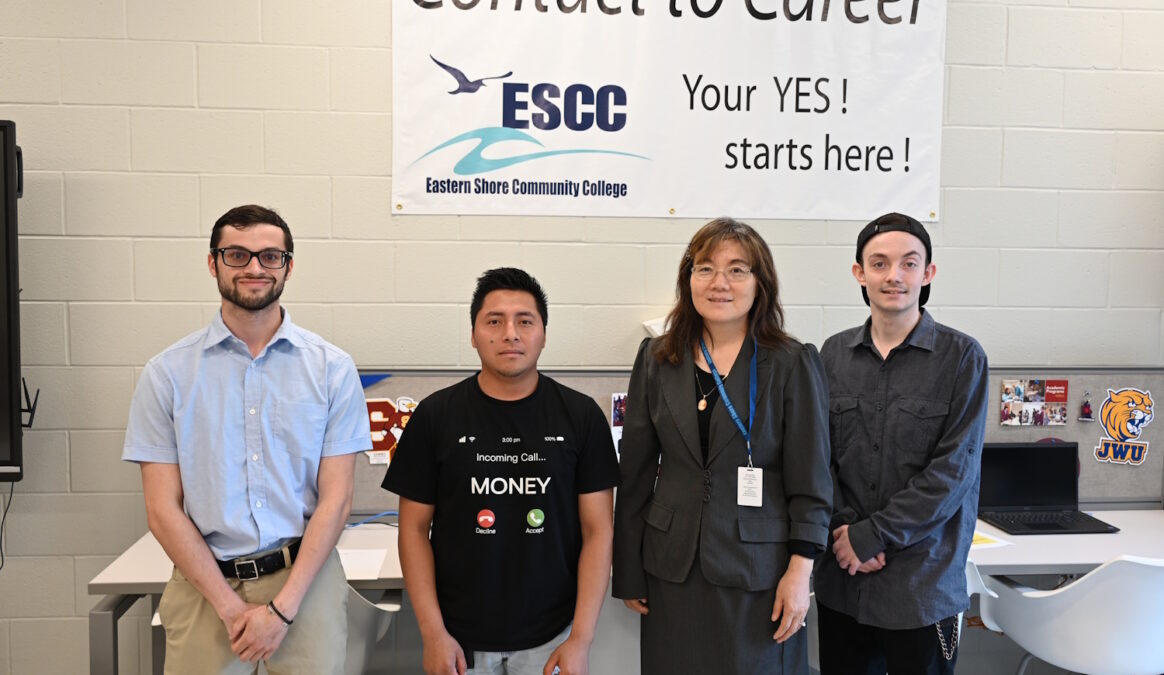 Four people standing in front of a Contact to Career sign