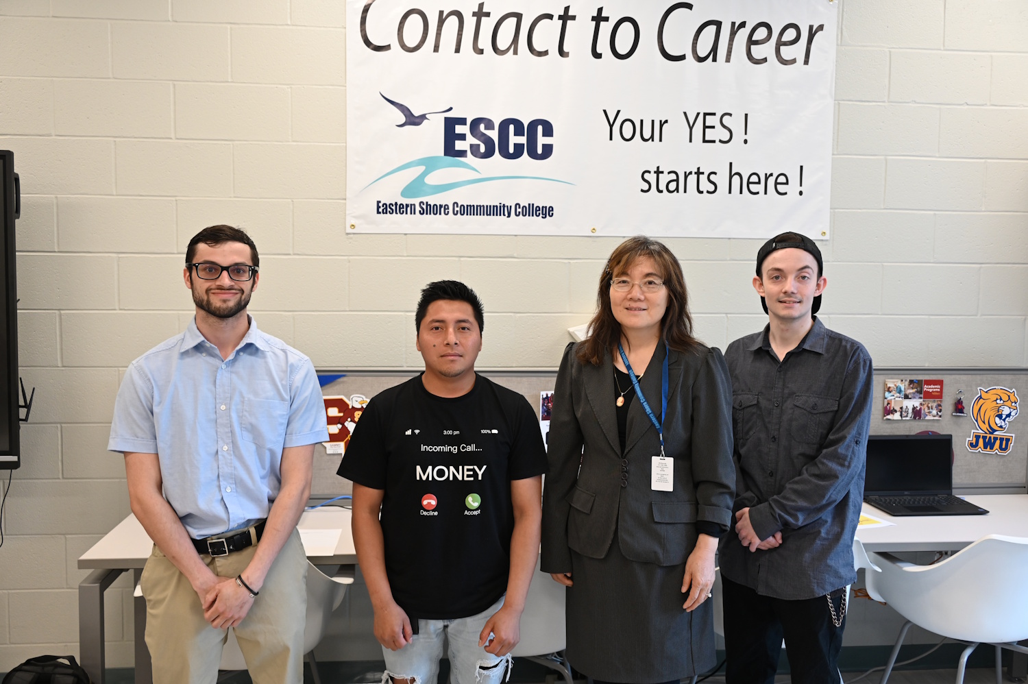 Four people standing in front of a Contact to Career sign