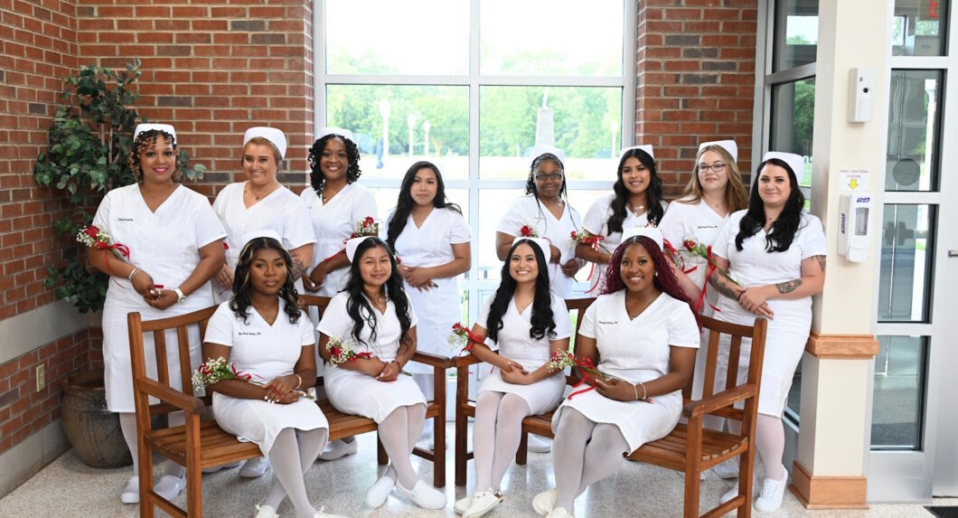 A group of women in nursing uniforms standing and seated