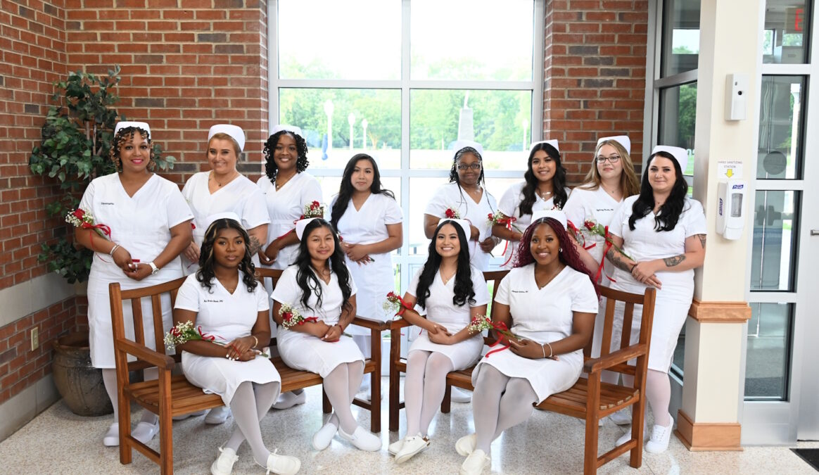 A group of women in nursing uniforms standing and seated