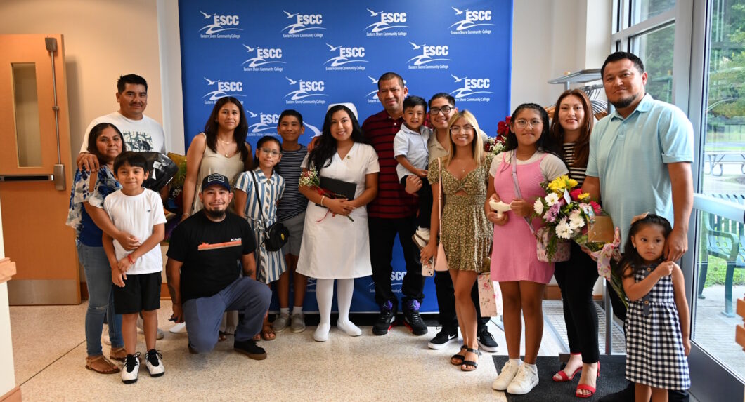 A large group of family members standing with their relative who just received her diploma