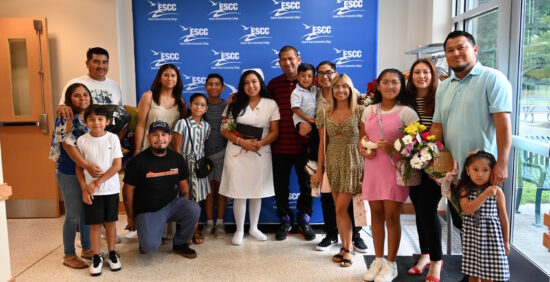 A large group of family members standing with their relative who just received her diploma