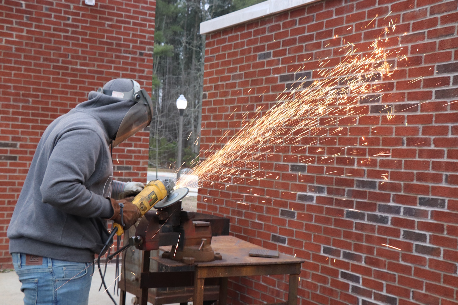 A person wearing protective gear and using an angle grinder