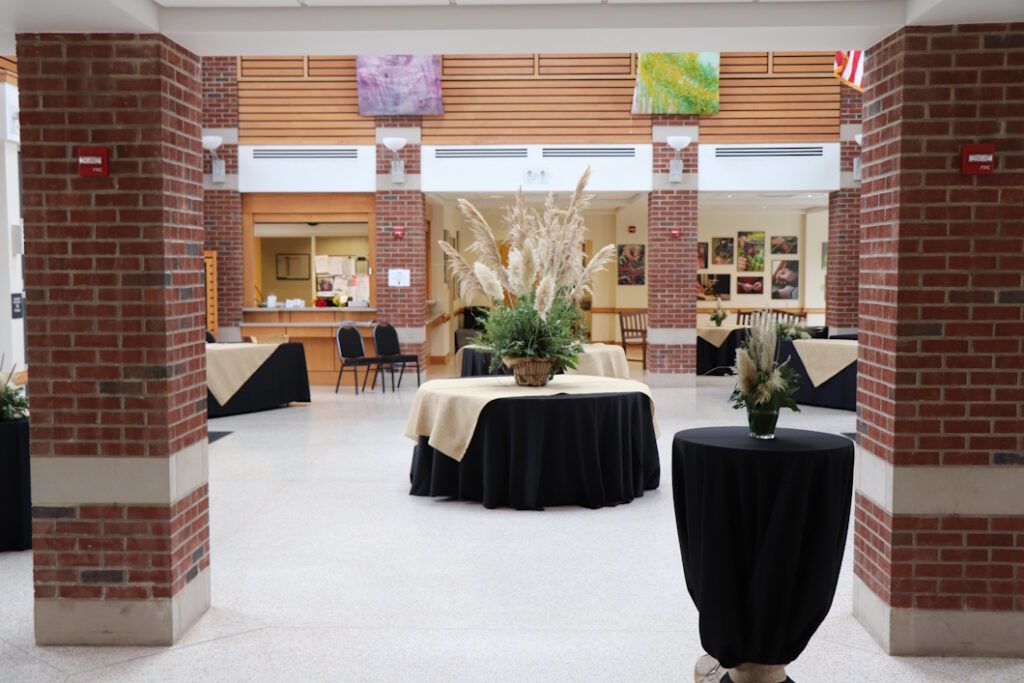 A group of tables with black tablecloths on them