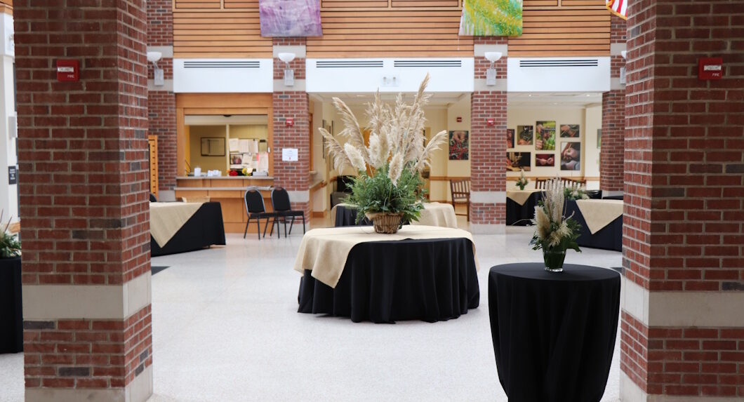 A group of tables with black tablecloths on them