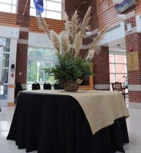 A round table with a black tablecloth on it and a centerpiece,